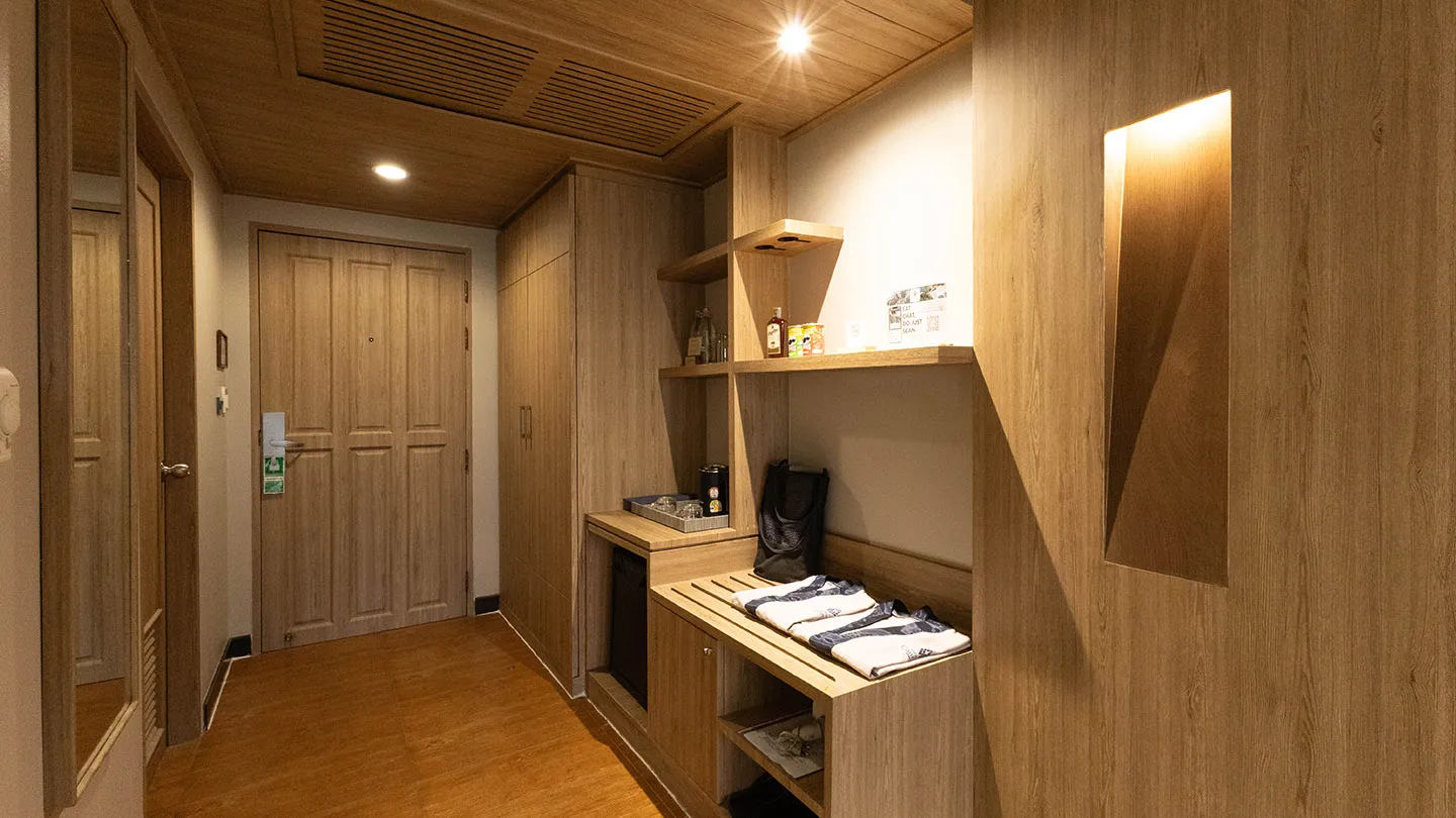 A full-length mirror on the left reflects the room and doorway, complemented by a wooden-door closet that integrates smoothly into the décor