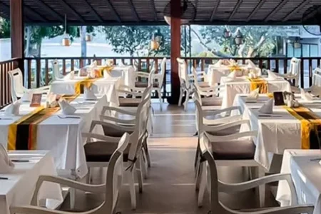 Dining setup with tables and chairs, showcasing the restaurant’s atmosphere overlooking Kata Beach